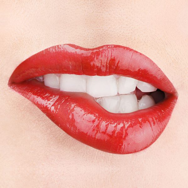 Raww - Coconut Splash Lip Gloss in the shade of Red Hot closeup image on a woman's lips