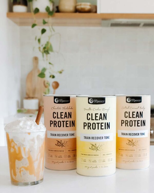 Three Flavour Varieties of Nutra Organics Clean Protein with a delicious smoothie on a kitchen table