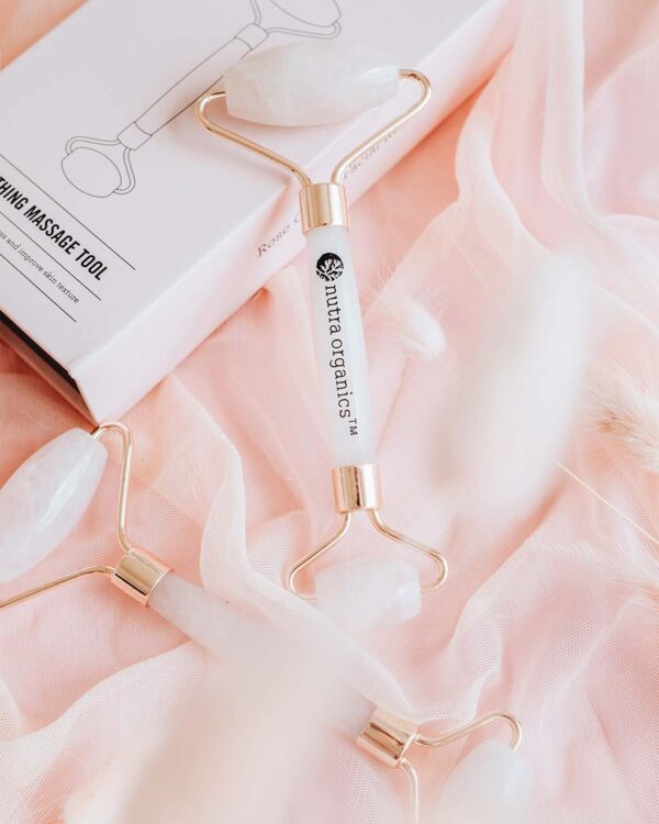 Nutra Organics Rose Quartz Facial Roller with packaging in a pink coloured styled image